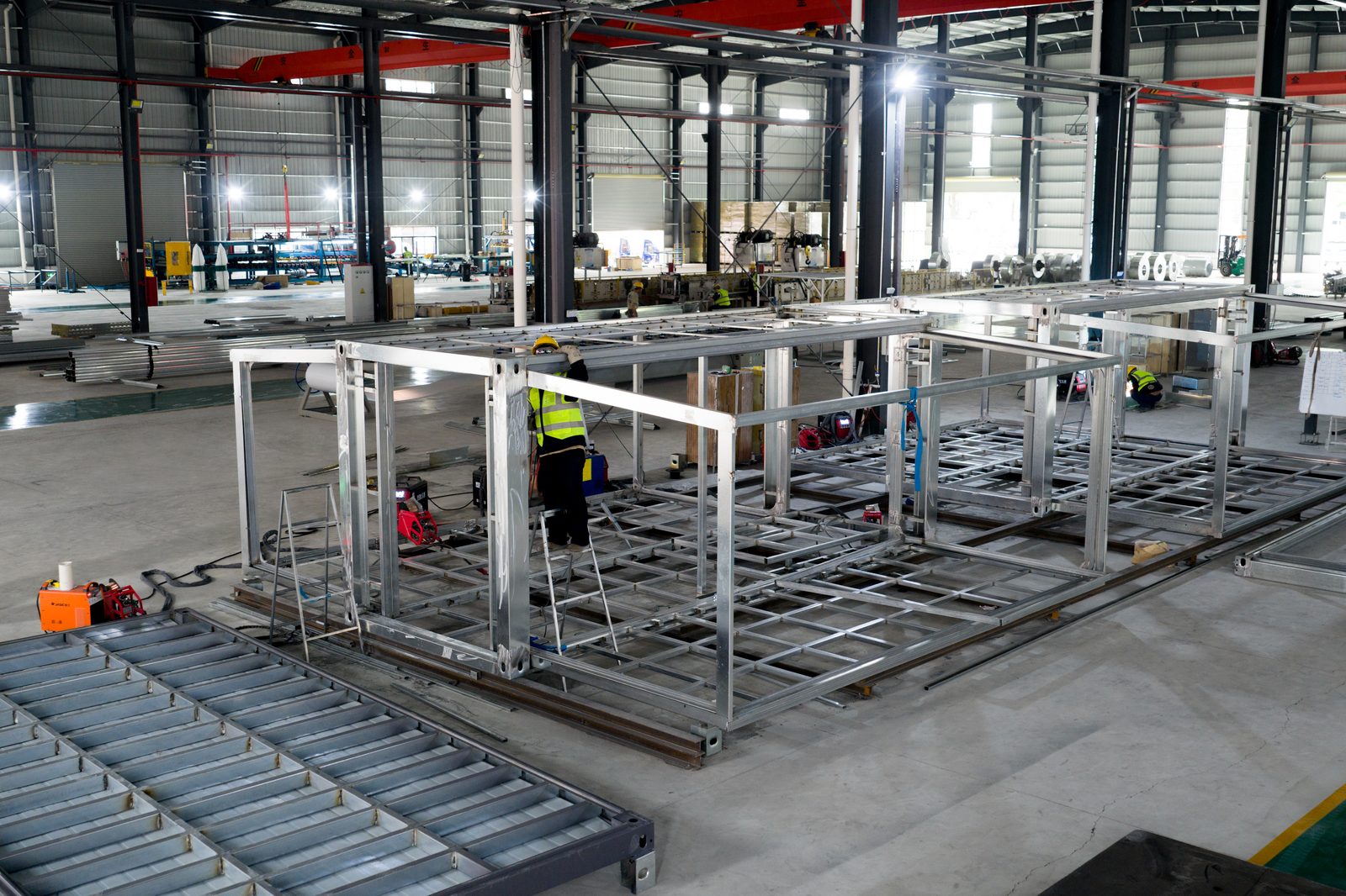 Workers assembling folding frames on jigs